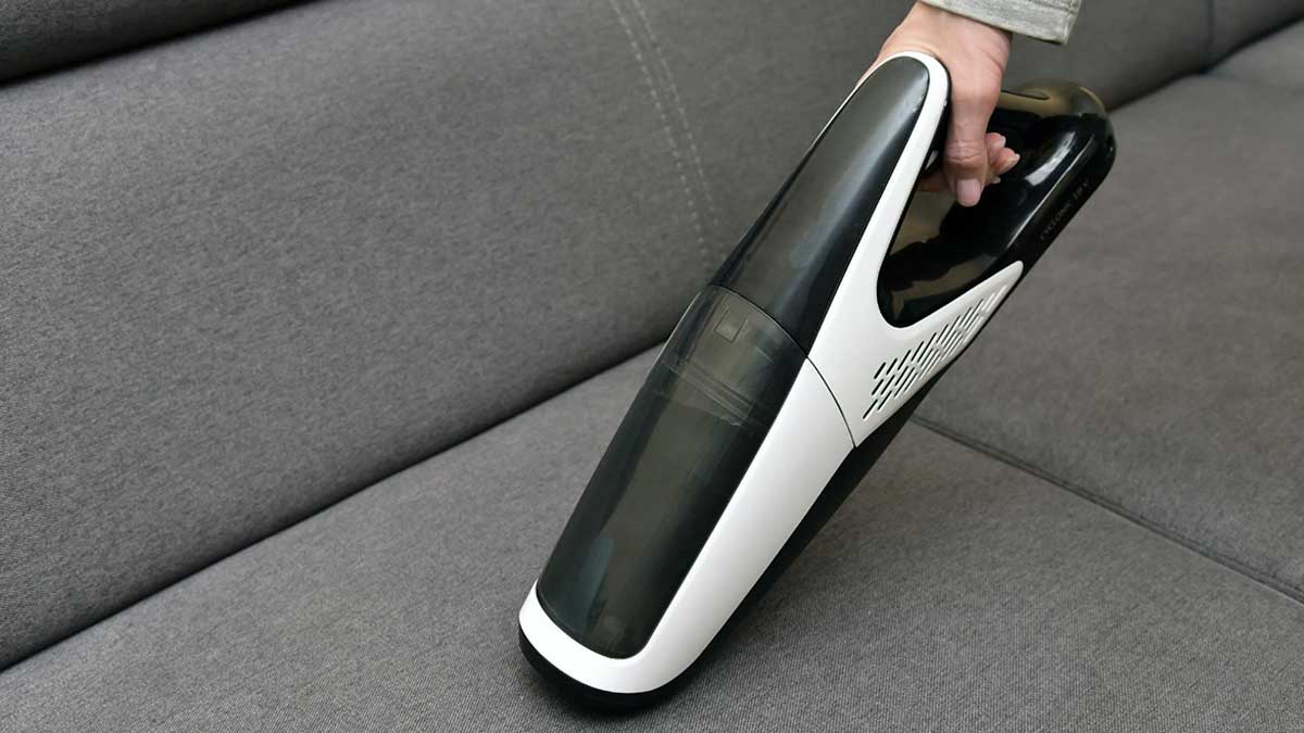 portable vacuum cleaner on sofa