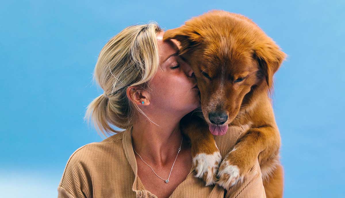 woman kisses dog